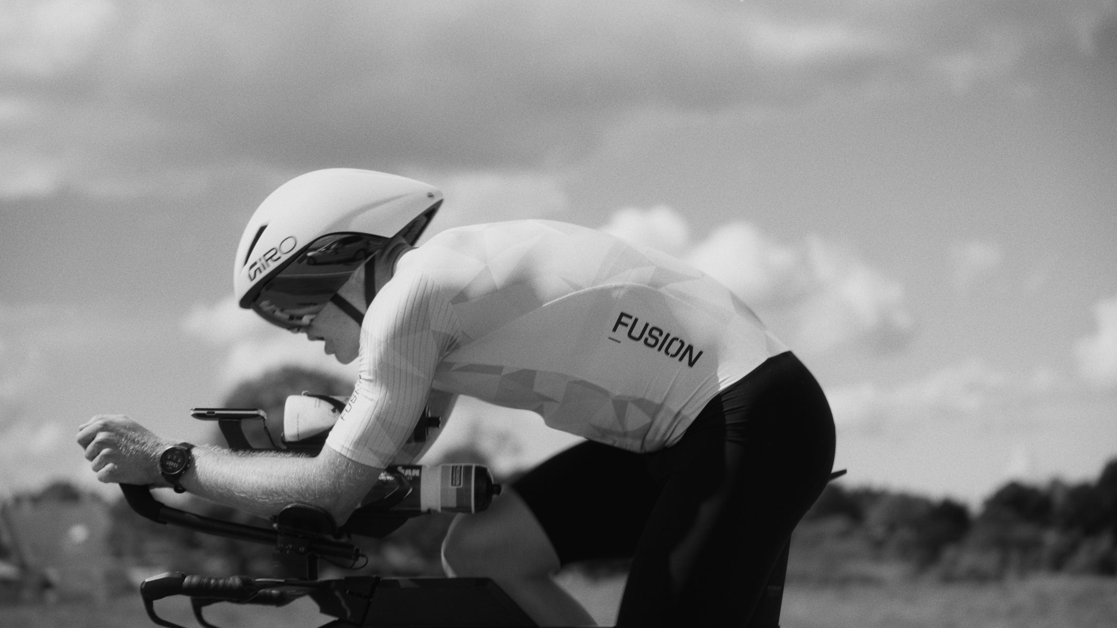 Time-trial cyclist in an aero helmet, black and white